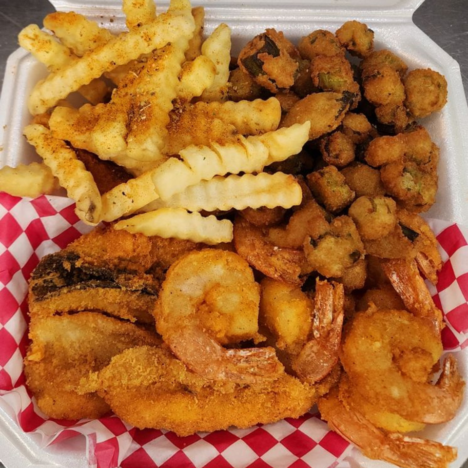 A takeout container filled with Levy's Soul Cafe's fried shrimp, okra, and crinkle-cut fries.