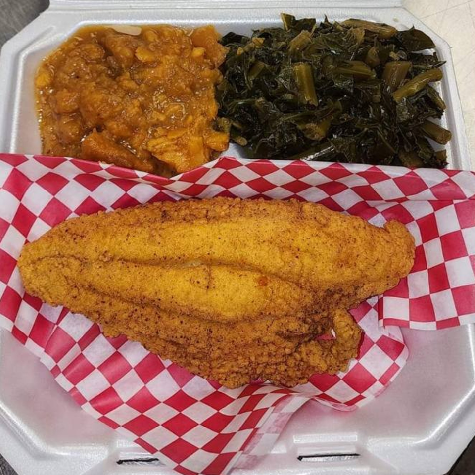 Fried catfish, candied yams, and collard greens in a styrofoam takeout container from Levy's Soul Cafe.